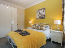 A bedroom with a bed and wardrobe at Ty Llwyd, Llandudno