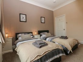 A bedroom with twin beds and bedside tables at Ty Llwyd in Llandudno