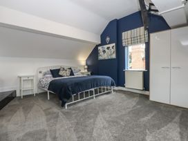 A bedroom with a bed and nightstand at Ty Llwyd in Llandudno