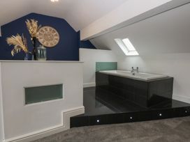 A bathroom with a bathtub and decorative elements at Ty Llwyd in Llandudno