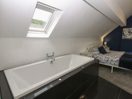 A bedroom with a bathtub and bed at Ty Llwyd in Llandudno