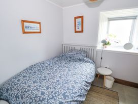 A bedroom with a bed and bedside table at Claddagh Tuss Holiday Cottage Clifton