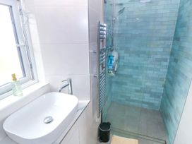 A bathroom with a sink and shower at Claddagh Tuss Holiday Cottage, Clifton