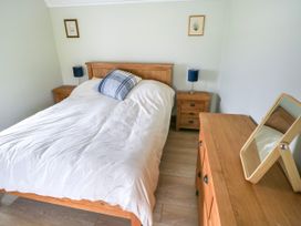 A bedroom with a bed and nightstand at Claddagh Tuss Holiday Cottage in Clifton