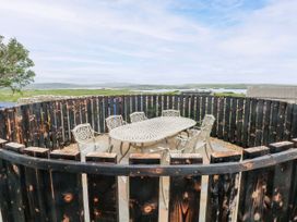 An outdoor area with a table and chairs at Claddagh Tuss Holiday Cottage in Clifton
