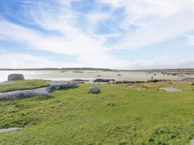 A coastal view with grass and rocks at Claddagh Tuss Holiday Cottage in Clifton