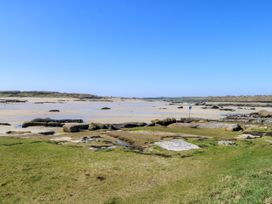A beach with rocks and water at Claddagh Tuss Holiday Cottage in Clifton