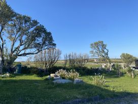 A garden with trees and rocks at Nead na bhFáinleog (Swallows’ Nest) Claddaghduff, County Galway