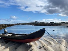 A boat on the sand near water at Nead na bhFáinleog (Swallows’ Nest), Claddaghduff, County Galway