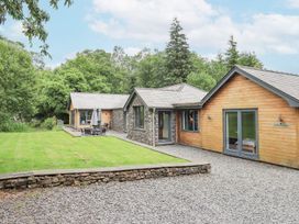 An outdoor view of a house with green grass and trees at Bracken Ground in Coniston