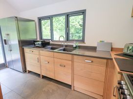 A kitchen with cabinets, sink, and fridge at Bracken Ground in Coniston