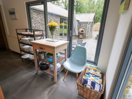 A kitchen with a table, chair, and utensils at Bracken Ground in Coniston