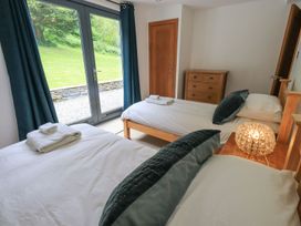 A bedroom with two beds and a dresser at Bracken Ground in Coniston