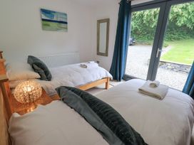 A bedroom with two beds and a large door at Bracken Ground in Coniston