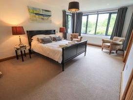 A bedroom with a bed and armchairs at Bracken Ground in Coniston