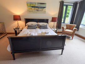 A bedroom with a bed and chair at Bracken Ground in Coniston