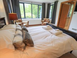 A bedroom with a bed and armchairs at Bracken Ground in Coniston