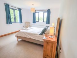 A bedroom with a bed and windows at Bracken Ground in Coniston