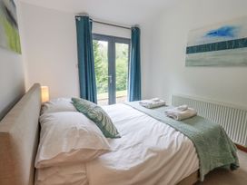 A bedroom with a bed and a view of greenery at Bracken Ground in Coniston
