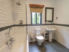A bathroom with a bathtub, toilet, and sink at Bracken Ground in Coniston