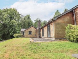 An exterior view of a house with a chimney and landscaping at Bracken Ground in Coniston