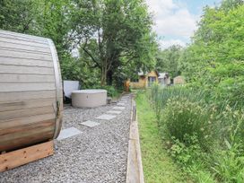 An outdoor area with a hot tub and a barrel sauna at Bracken Ground in Coniston