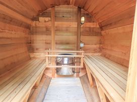 A sauna with wooden benches and a stove at Bracken Ground in Coniston