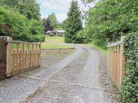 A gravel road leading to a house surrounded by trees at Bracken Ground in Coniston