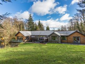 A house with a deck and patio in a grassy area at Bracken Ground in Coniston
