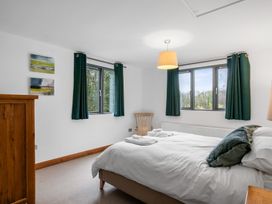 A bedroom with a bed and windows at Bracken Ground in Coniston