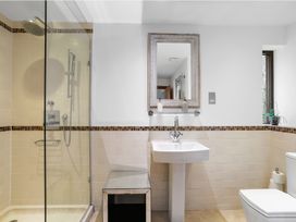A bathroom with shower, sink, mirror, and toilet at Bracken Ground in Coniston