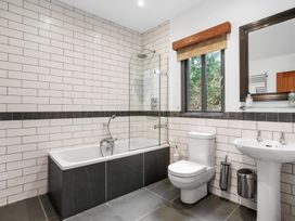 A bathroom with a bathtub, shower, toilet, and sink at Bracken Ground in Coniston