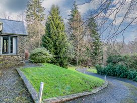 A house and garden with trees and a gravel pathway at Bracken Ground in Coniston