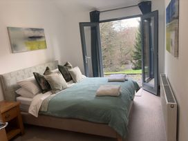 A bedroom with a bed and open windows at Bracken Ground in Coniston