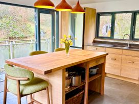 A kitchen with a wooden island and bar stools at Bracken Ground in Coniston