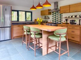 A kitchen with a countertop and bar stools at Bracken Ground in Coniston