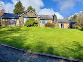 A house surrounded by lawn and trees at Bracken Ground Coniston