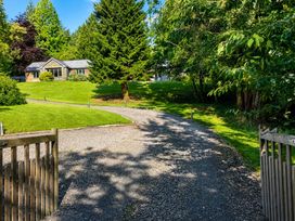 A view of a house and driveway surrounded by trees at Bracken Ground in Coniston