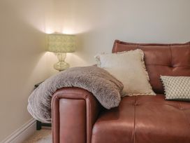 A sofa with cushions and a lamp at Foxes Den Pendomer near Yeovil, Somerset