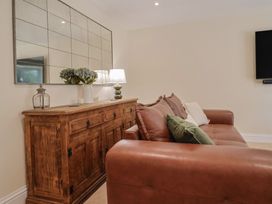 A living room with a sofa and a sideboard at Foxes Den in Pendomer near Yeovil, Somerset