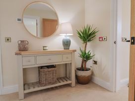 A hallway with a console table and a mirror at Foxes Den Pendomer near Yeovil, Somerset
