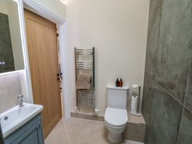 A bathroom with a toilet, sink, and towel rack at Foxes Den in Pendomer near Yeovil, Somerset