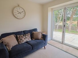 A living room with a sofa and large window at Foxes Den, Pendomer near Yeovil, Somerset