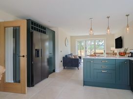 A kitchen with a refrigerator, cabinets, and a sofa at Foxes Den, Pendomer near Yeovil, Somerset