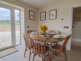 A dining room with a round table set for a meal at Foxes Den Pendomer near Yeovil Somerset