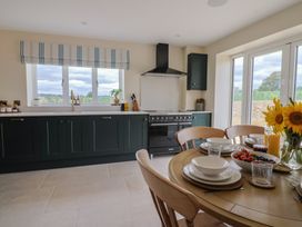 A kitchen with a dining table and sunflowers at Foxes Den in Pendomer near Yeovil, Somerset
