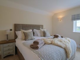 A bedroom with a bed, side table, and lamp at Foxes Den in Pendomer near Yeovil, Somerset