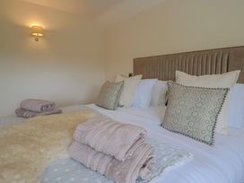 A bedroom with a bed and towels at Foxes Den, Pendomer near Yeovil, Somerset