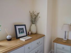 A living room with a dresser, picture frame, and decorative items at Foxes Den, Pendomer near Yeovil, Somerset