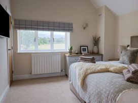 A bedroom with a bed and window at Foxes Den Pendomer near Yeovil Somerset